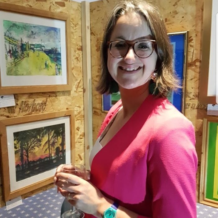 Katie with her art at an exhibition.